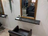 a picture of a hair salon with chairs and a mirror