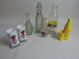 Des bouteilles et des tasses sont posées les unes à côté des autres sur une table.