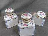 three small containers with flowers on them on a table