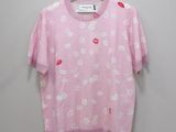 a pink shirt with white flowers on it hanging on a hanger