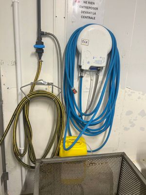 un panier métallique auquel est fixé un tuyau bleu