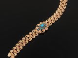 a gold bracelet with a turquoise stone in the center