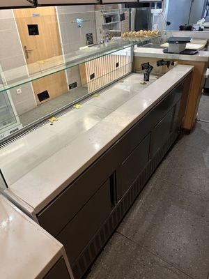 a counter with a glass display case in the middle of the room