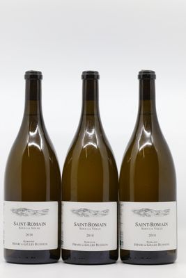 trois bouteilles de vin posées les unes à côté des autres sur une surface blanche