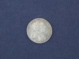 a close up of a silver coin on a blue cloth