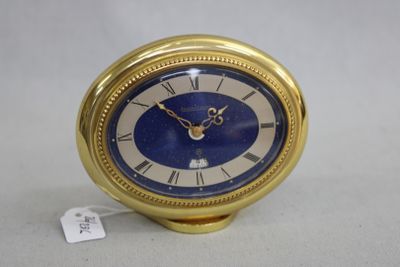 une horloge dorée au cadran bleu posée sur une table