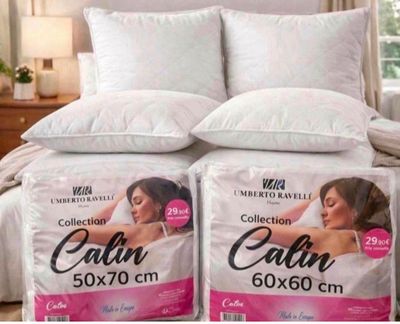 deux boîtes d'oreillers Calin posées sur un lit dans une chambre