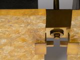 a close up of a gold colored lamp on a white table