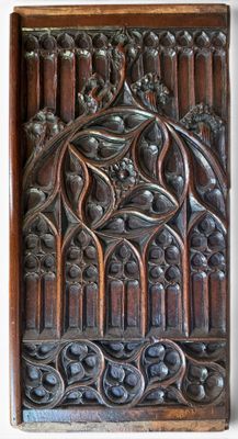 carved wood panel with a bird and flowers on it