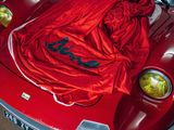 a red car with a red blanket on top of it