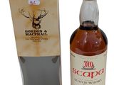 une bouteille de whisky écossais posée devant un carton