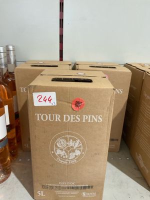 Plusieurs bouteilles de vin sont posées sur un comptoir, à côté d'un carton.