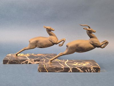 paire de sculptures de cerfs en bronze sur socle de marbre, sur fond bleu