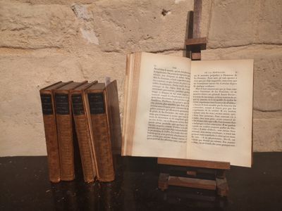 trois livres posés sur une table à côté d'une croix