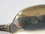 a silver spoon with a hole in it sitting on a table