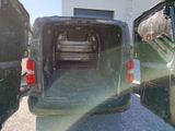 vehicles parked in a lot with the doors open and the back of the van open