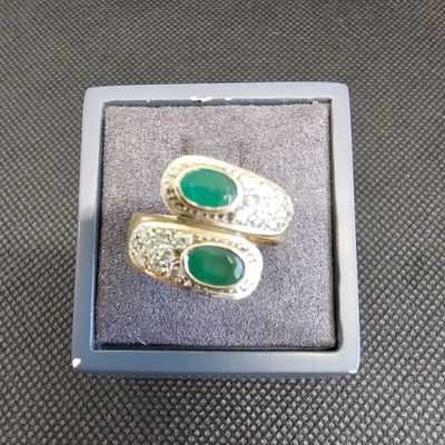 une paire de boucles d'oreilles en émeraude et diamant, présentée dans un coffret cadeau