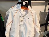 a white jacket hanging on a rack in a clothing store