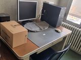 a desk with two computer monitors and a box on it