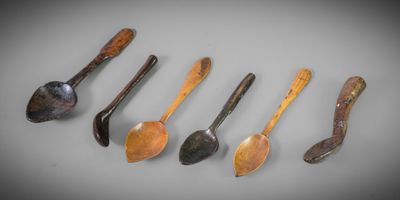six wooden spoons are lined up in a row on a table