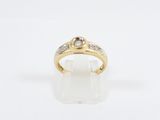 a yellow gold ring with a diamond set in the center
