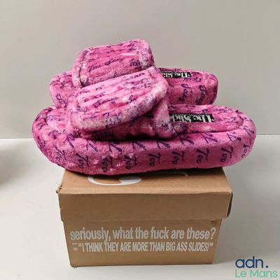 une pantoufle rose posée sur une boîte en carton