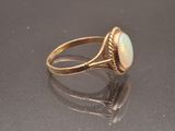an antique gold ring with a white opalite stone in the center