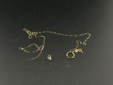 un gros plan sur une paire de boucles d'oreilles en or posées sur une surface noire