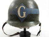 a helmet with the letter g on it on a stand