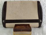 a brown and tan purse sitting on a table next to a small box