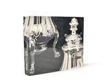 un livre sur lequel figure l'image d'un vase en argent et d'une lampe