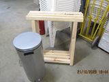 a trash can sitting next to a stack of chairs in a warehouse
