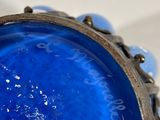 a close up of a ring with a blue glass on it