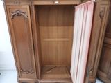 a wooden cabinet with a pink curtain in it