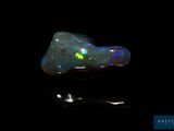a black oplite with green and blue speckles on a black background