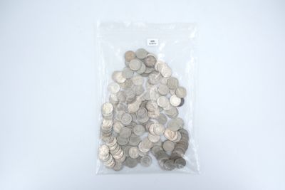 un sac rempli de pièces d'argent posé sur une surface blanche