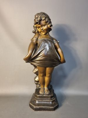 statue d'une petite fille en robe, debout sur un socle