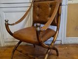 a brown leather chair sitting on a hard wood floor