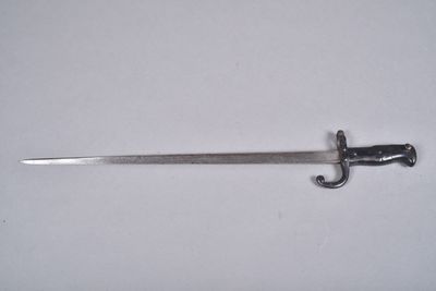 a close up of a sword on a white surface