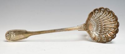 cuillère plaquée argent avec un manche en forme de coquillage sur un fond blanc