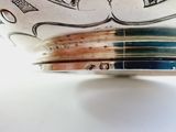 a close up of a silver bowl with designs on it