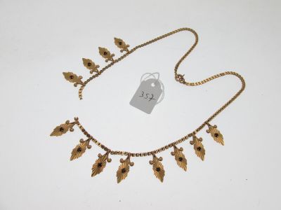 une image représentant un collier en or orné de fleurs et de feuilles