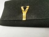 black clutch bag with gold y on it sitting on a white surface