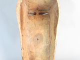 an image of a wooden mask on a stand against a white background