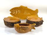 yellow fish shaped dishes and bowls are sitting on a white surface