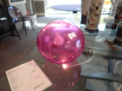 une table en verre sur laquelle se trouve une balle rose
