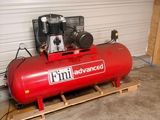 a red air compressor sitting on a pallet in a garage