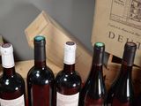 several bottles of wine are lined up in a wooden box