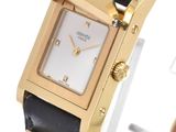 a close up of a gold and black watch with a white face