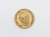 a close up of a gold coin on a white surface